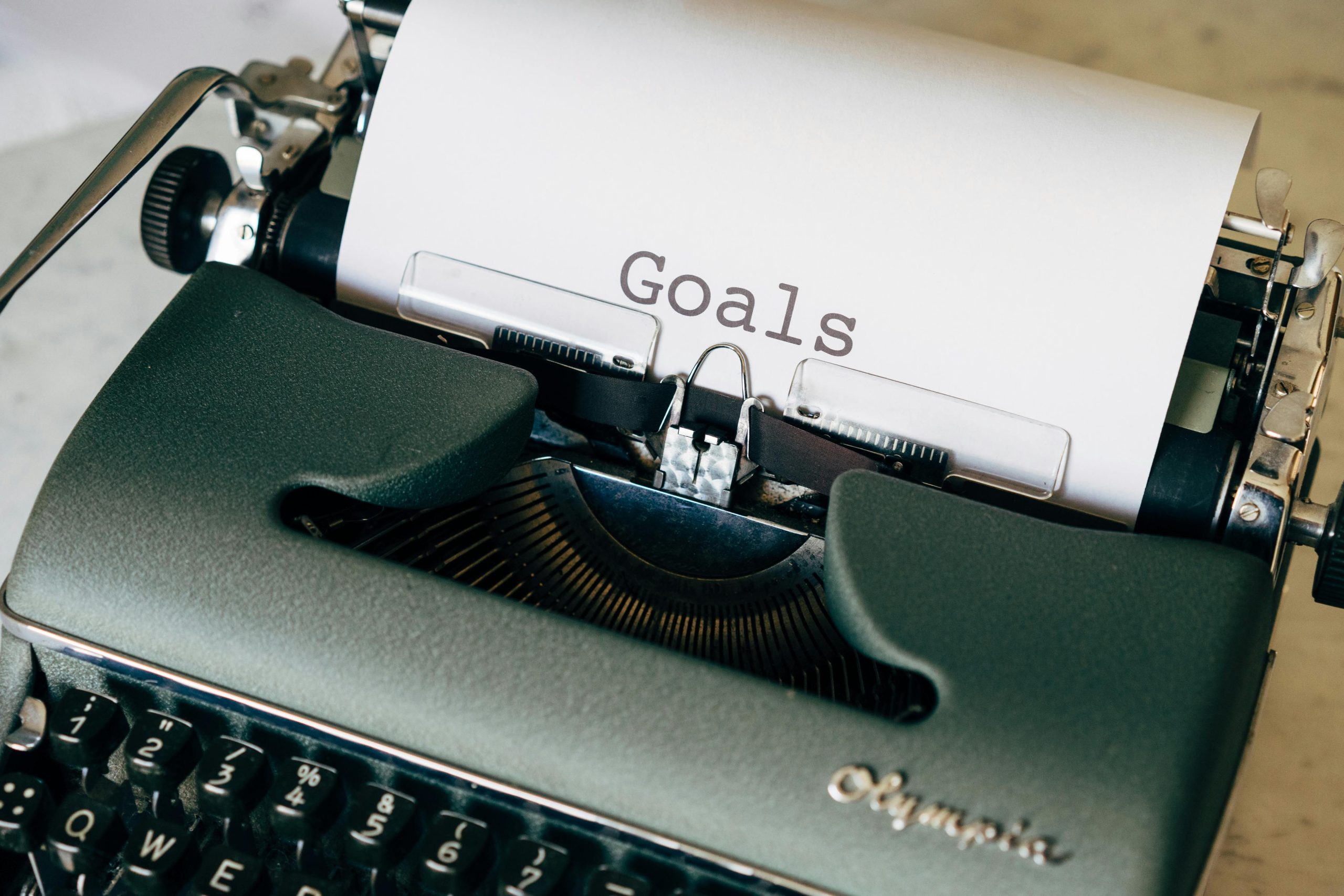 A vintage typewriter with the word "Goals" typed on a sheet of paper, symbolizing strategic real estate investment planning.